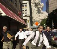 people running as tower crumbles